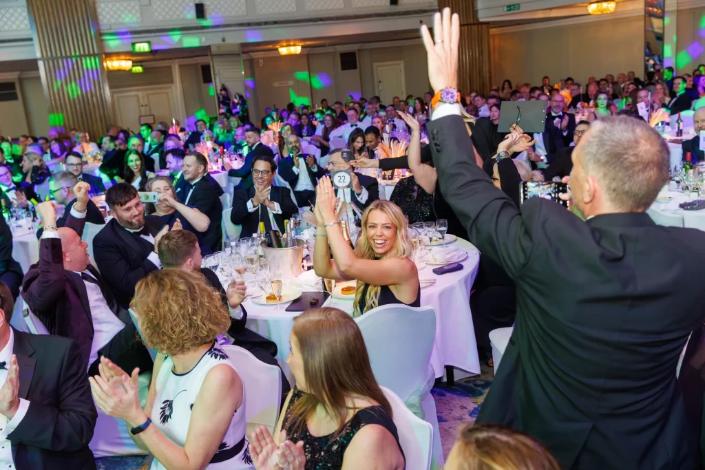 Nominee of the British Business Excellence Awards standing up to receive his award.