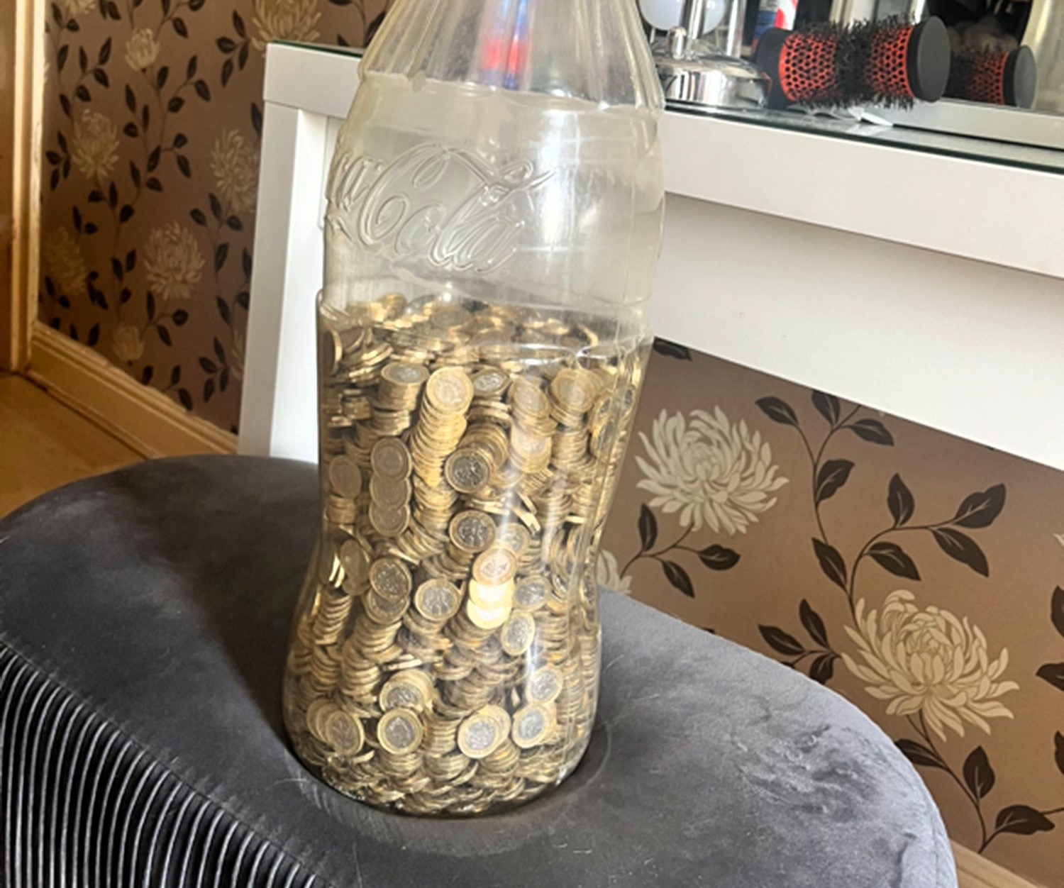 West Yorkshire man saves £5,000 by collecting £1 coins in a Coca-Cola bottle over four years. His TikTok video revealing the total goes viral with 1.6 million views.